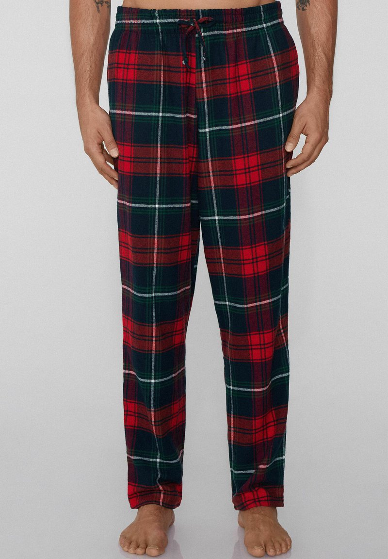 Czerwono-czarne piżamowe spodnie w kratę wykonane z miękkiego materiału, z elastycznym paskiem i sznurkiem do regulacji, idealne do noszenia w domu.
