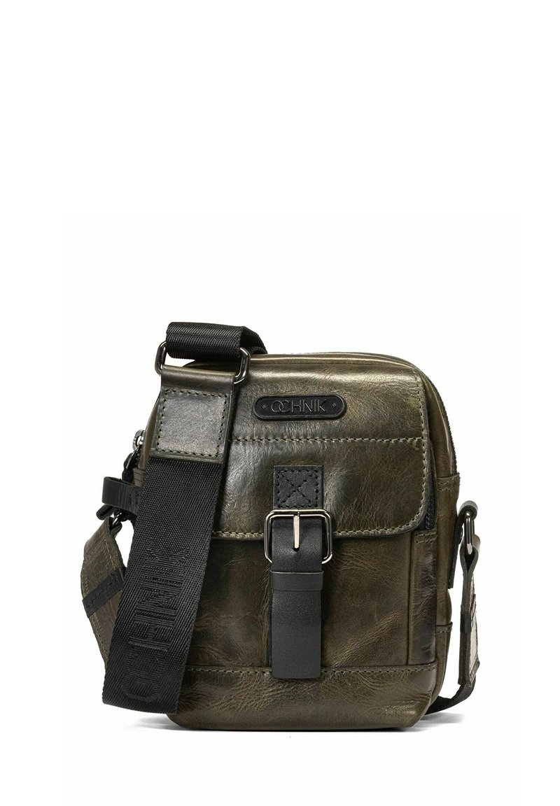 Pudrowo zielona skórzana torba na ramię z przednią klapą, czarną zapięciem w akcentującym kolorze i regulowanym paskiem, z teksturowanym wykończeniem i detalami logo.