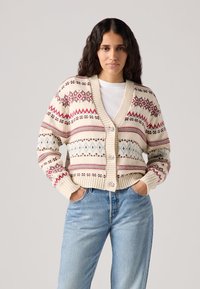 Knit cardigan in cream with red and blue geometric patterns, featuring a V-neck, ribbed cuffs, three buttons, and a relaxed fit.