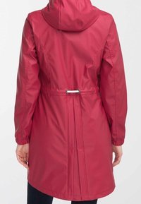 Red waterproof jacket with a fitted design, elastic cuffs, drawstring waist, and a hood. Smooth fabric with a subtle sheen.