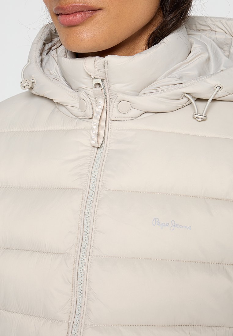Giacca imbottita beige realizzata in materiale trapuntato, dotata di cappuccio, zip, bottoni a pressione e delicato logo del marchio sul petto.