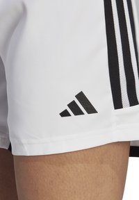 Weiße Sportshorts mit schwarzem Dreistreifen-Design an der Seite, versehen mit einem schwarzen Adidas-Logo unten links. Glattes, leichtes Material.
