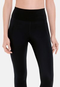Zwarte high-waisted leggings van rekbare stof, met zijpanelen met een subtiel textuurpatroon en platte naden voor comfort.