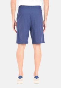 Pantaloni corti blu navy con elastico in vita, che arrivano appena sopra il ginocchio, realizzati in tessuto leggero, con una texture liscia e senza motivi visibili.