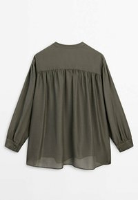 Olive green long-sleeve blouse, soft fabric, loose fit, rounded collar, gathered back detail, buttoned cuffs, semi-sheer texture.