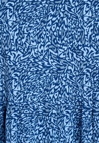 Zils audums ar vētrainu abstraktu rakstu dažādās zilās un pelēkās toņos, ar mīkstu, strukturētu virsmu.