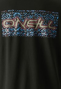 Camiseta negra con un diseño gráfico colorido que presenta un patrón tribal en azul, negro y rosa, y la palabra "O’Neill" en una fuente negrita.