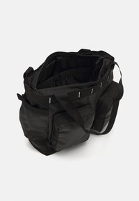 Saco de tecido preto com múltiplos compartimentos, fechos e alças longas. Apresenta um exterior texturizado e um interior espaçoso.