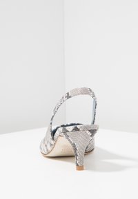 Sandal con tacco slingback con stampa serpente grigia e nera, tacco basso, interni in pelle liscia e una superficie esterna testurizzata.