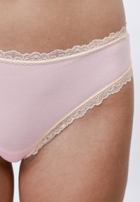 Cuecas hipster de tecido rosa claro com um elegante acabamento de renda recortada em tom bege ao longo da cintura e das cavas.