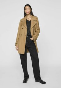 Kamelfärgad dubbelknäppt trenchcoat med en avslappnad passform, som har breda slag, knappdetaljer och svarta raka byxor.