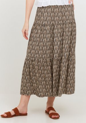 Gonna midi marrone con motivo, realizzata in tessuto leggero, caratterizzata da un design a strati e sottili contrasti di texture. Abbinata a sandali scivolati marroni.