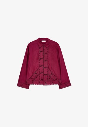 Bordeauxbluse med krave-design, prydet med blondedetaljer langs knapper og kanter. Lange ærmer og en afslappet pasform.