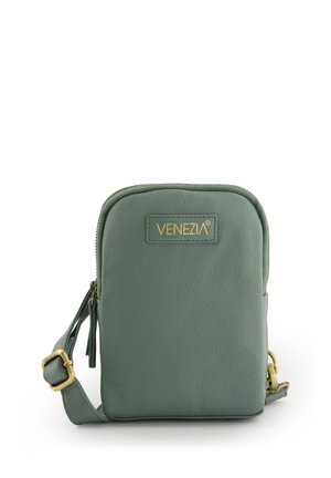 Zielona skórzana torebka typu crossbody z teksturowanym wykończeniem, złotymi akcentami metalowymi oraz zapięciem na zamek. Ma na przodzie oznaczenie marki.