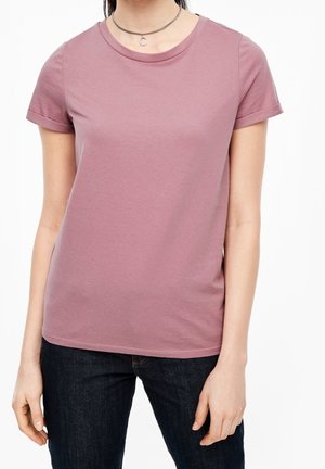 T-shirt à manches courtes et col rond en coton mauve clair, présentant une texture lisse et des coutures visibles le long de l'ourlet et des manches.