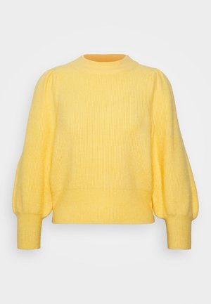 Pull jaune en tricot avec manches longues bouffantes et poignets et ourlet côtelés sur un fond clair uni.