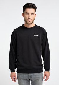 Felpa nera in pile con maniche raglan, girocollo e tessuto testurizzato. Presenta un logo bianco "TUFFSKULL" sul petto.