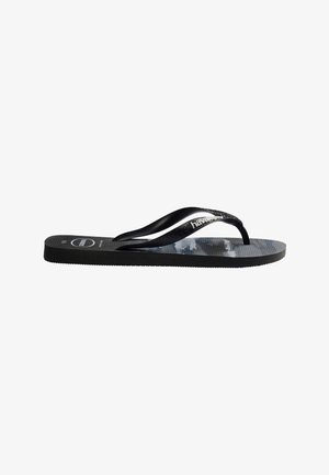 Sandale flip-flop noire avec semelle texturée, brides noires et logo blanc « Havaianas » sur la bride, vue de côté.