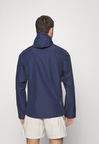 Marine vanntett jakke med hette, lange ermer og glatt tekstur. Designet er funksjonelt, egnet for utendørsaktiviteter.