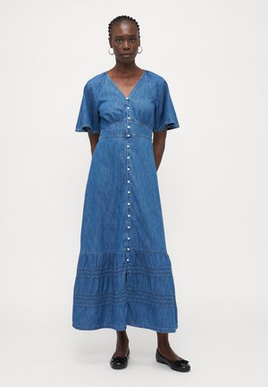 Vestido maxi de mezclilla con escote en V, mangas cortas con vuelo, cierre delantero con botones y dobladillo de volantes en capas. Presenta un tono azul claro y está fabricado en mezclilla.