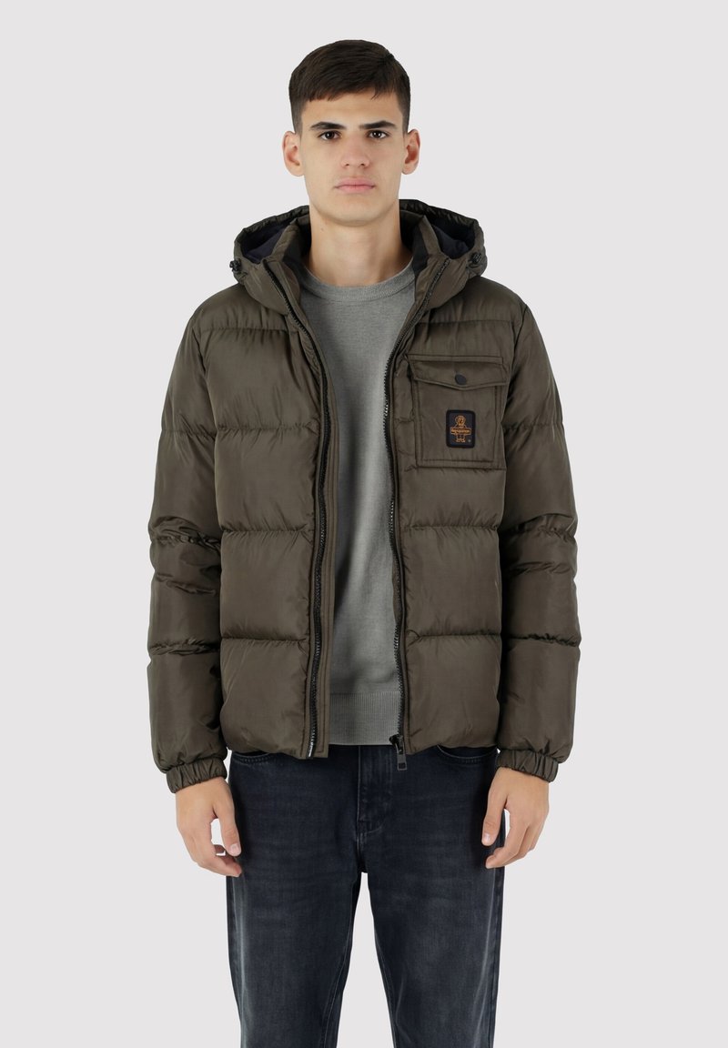 Giacca imbottita verde oliva, con chiusura a zip e cappuccio. Presenta polsini elastici e una tasca sul petto con dettaglio logo.