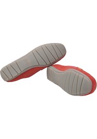 Rote Wildlederschuhe mit einer flexiblen Gummisohle, die ein strukturiertes Muster und minimale Nähte am Rand aufweisen.