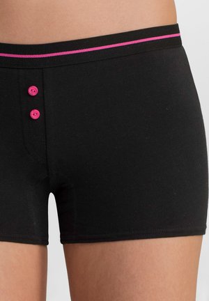 Shorts en coton noirs avec une ceinture rose, agrémentés d'une fine bande rose contrastante et de deux boutons roses à l'avant, près de la taille.
