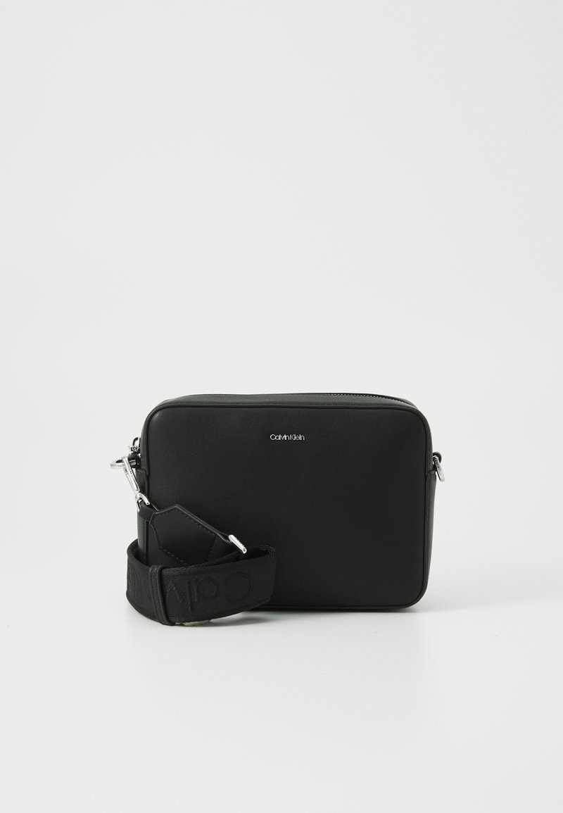 Black rectangular crossbody bag made from smooth material, featuring a detachable strap with logo and silver hardware accents.