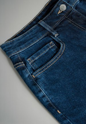 Granatowe jeansy z denimu z przednią kieszenią, kontrastowym złotym haftem i metalowym zapięciem. Gładka tekstura z lekkim połyskiem.