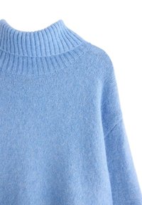 Maglione azzurro chiaro lavorato a maglia con collo alto a costine e texture morbida. Il tessuto sembra caldo e accogliente, adatto a temperature più fredde.