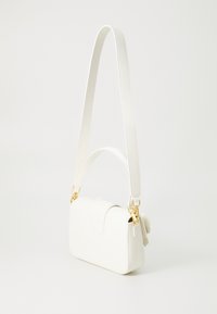 Sac bandoulière en cuir blanc de forme rectangulaire, avec des accessoires en or et un accent floral sur un côté. Texture lisse, bandoulière ajustable.