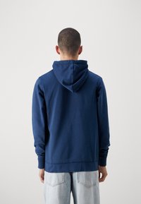 Felpa blu navy con cappuccio regolabile, polsini a coste e vestibilità comoda, realizzata in tessuto morbido, caratterizzata da un design semplice.