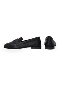 Schwarze Lederloafer mit flachem Absatz, ausgestattet mit einem dekorativen Riemen und metallischen Beschlägen, glatter Textur und einem eleganten, schlanken Design.