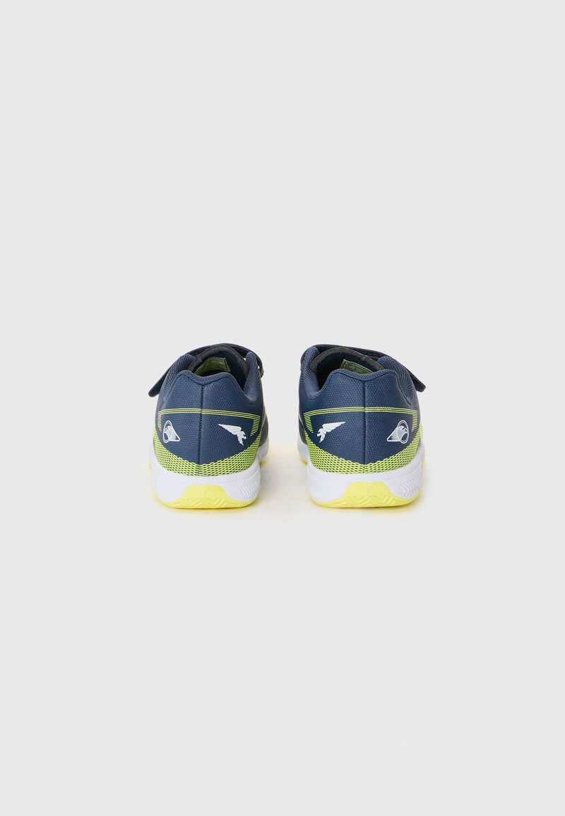 Zapatillas deportivas azules con material texturizado, acentos amarillos y una suela blanca. Cuentan con una correa de velcro y un logotipo en el talón.