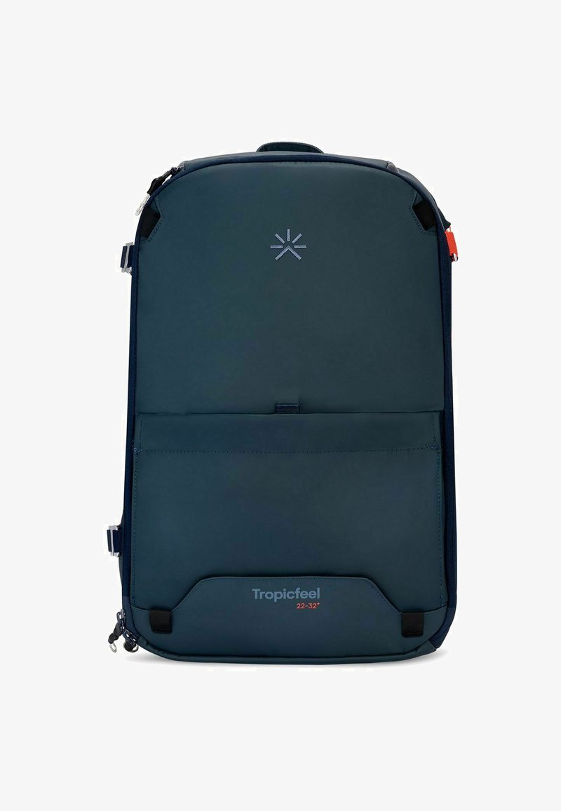 Mochila azul marino hecha de tela suave, con un bolsillo frontal, logotipo en la parte superior y cremalleras a los lados para acceso y cierre.