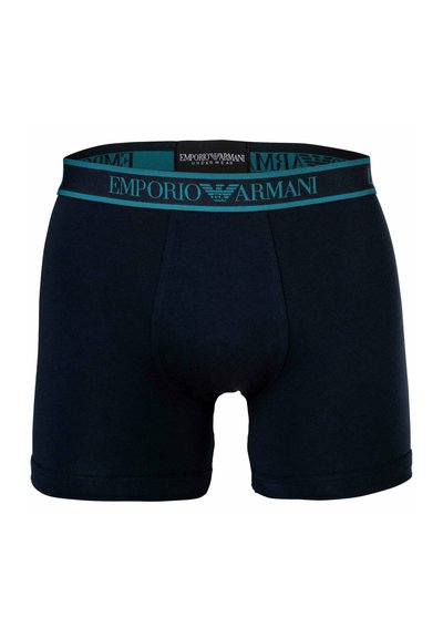 Temno modri bombažni boksarji s turkiznim elastičnim pasom, ki vsebuje blagovno znamko "Emporio Armani". Srednje dolžine z oprijetim krojem.