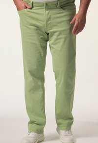 Pantalones de mezclilla verde claro con corte recto, que cuentan con un cierre de botón único, bolsillos frontales y una textura sutil. Combinados con zapatillas blancas.
