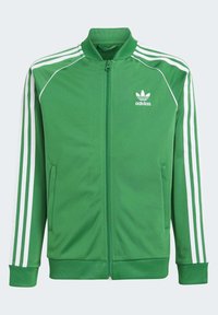 Chaqueta de deporte verde de Adidas con tres franjas blancas en las mangas, cremallera frontal, bolsillos y logo en el lado izquierdo del pecho.