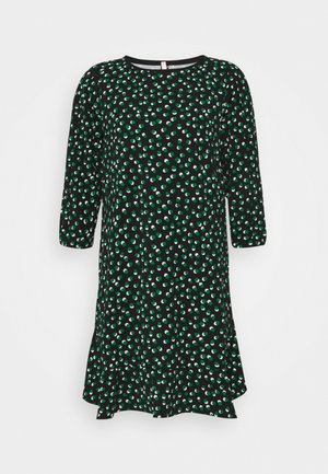 Robe noire à manches longues avec motif à points verts et blancs irréguliers et ourlet à volants.