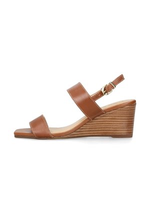 Sandale en cuir marron à talon compensé, avec deux larges sangles et une bride ajustable à la cheville. Le talon en bois texturé ajoute de la hauteur et de la stabilité.