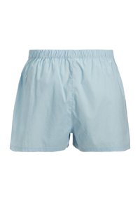 Light blue men's loose-fitting boxer shorts with elastic waistband and stitched hem, shown from the front on a white background.