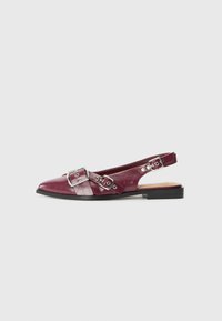 Burgundy leather slingback shoes with pointed toes, featuring decorative silver buckles and a flat black sole. Smooth texture and modern design.