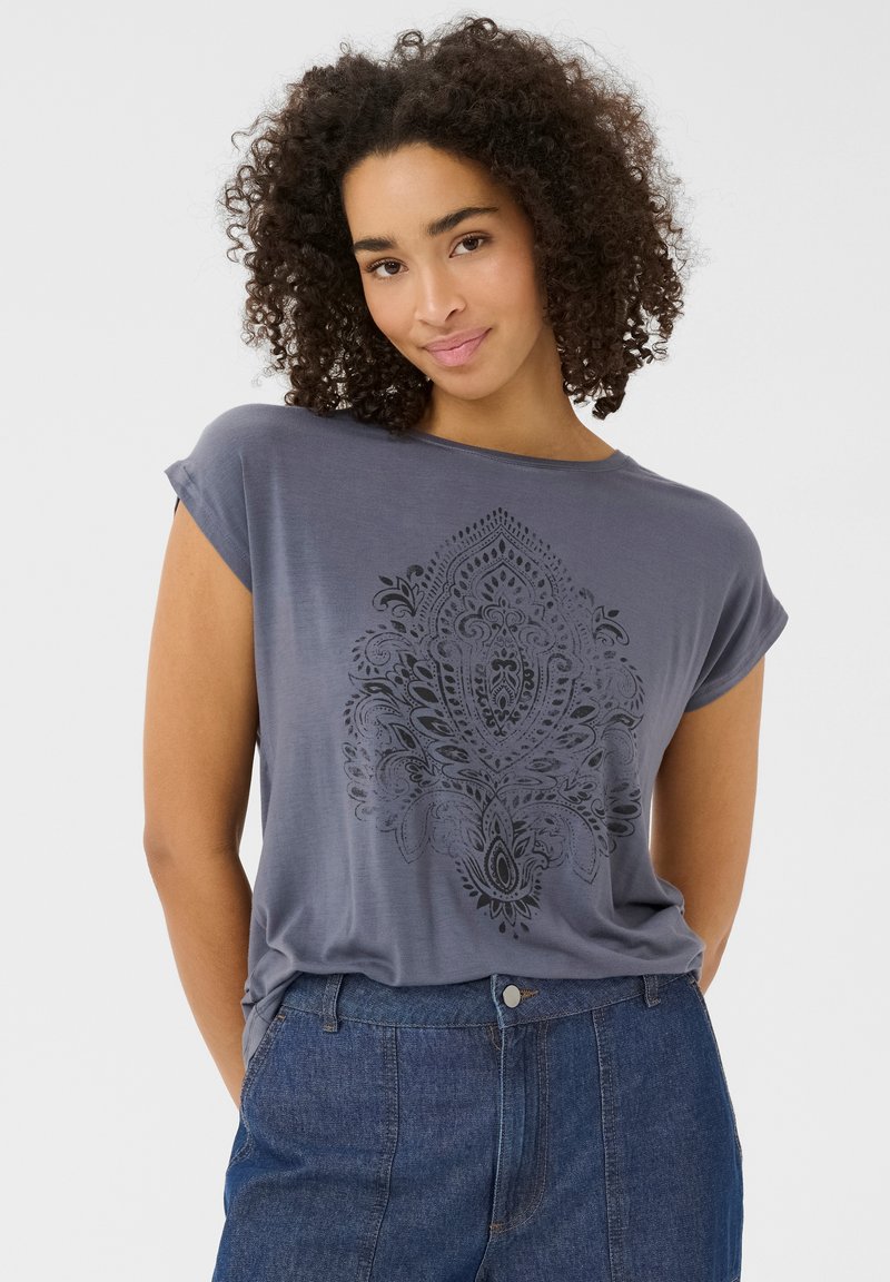 Gray short-sleeve shirt made of soft fabric, featuring a black paisley pattern on the front. Paired with denim pants, standing against a neutral background.