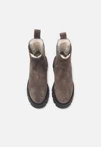 Pruunid seemsest ankle saapad tekstuuriga viimistluse, sulevoodri ja robustse musta kummitaldiga. Omab tõmbejuhte mugavaks jalga panekuks.