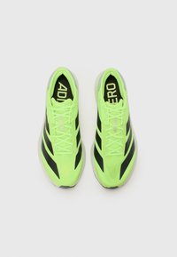 Heldergroene sportschoenen met zwarte accenten, met een slank ontwerp, textuur-mesh bovenkant en opvallende branding op de tong.