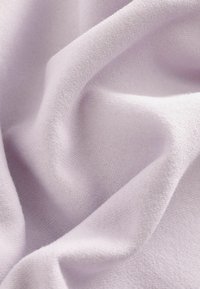 Tejido de algodón de color púrpura claro con una textura suave y lisa, que presenta caídas suaves y sutiles variaciones en el color.