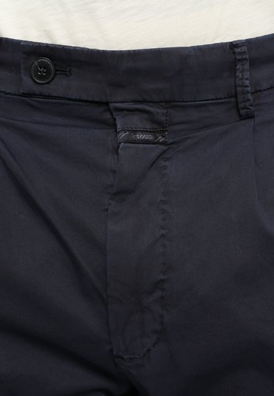 Navy trousers with a button closure, stitched detailing along the waistband, and a textured finish. Features a "CLOSED" tag on the side.