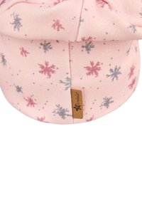 Pink cotton hat with snowflake pattern in gray and red. Features a rolled brim and a small brown logo tag. Soft texture.