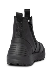 Botín negro de piel con un panel trasero texturizado, cremallera lateral y suela de goma resistente con surcos para mayor tracción.