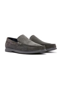 Mocassins en suède gris avec une texture lisse, un design à enfiler et un détail de couture contrastante le long du bord. Semelle en caoutchouc en dessous.